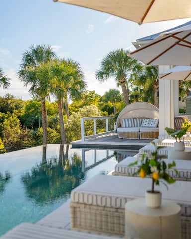 Poolside terrace with palm trees, infinity pool, and daybed seating